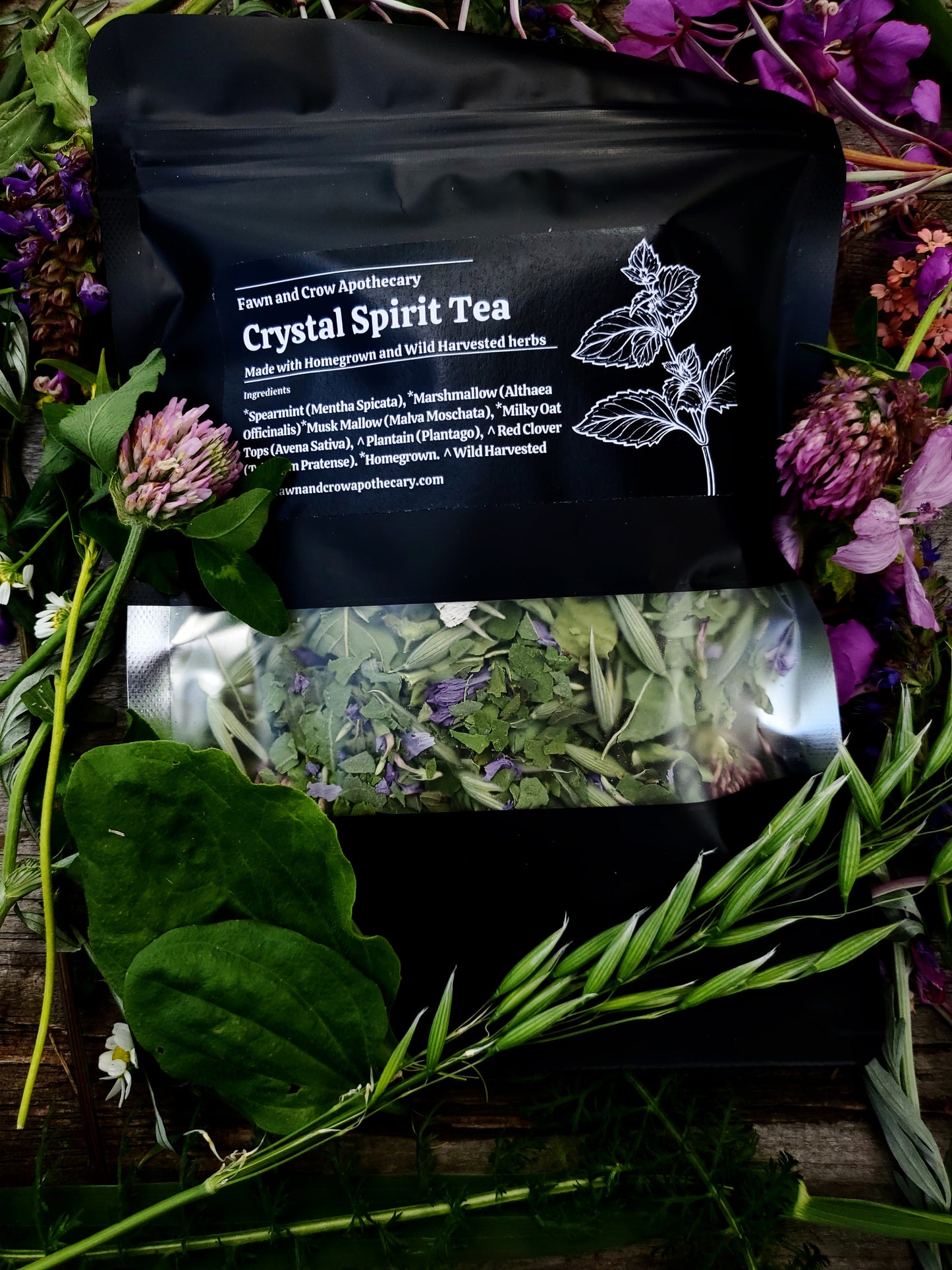 Medicinal tea blend in black pouch surrounded by flowers
