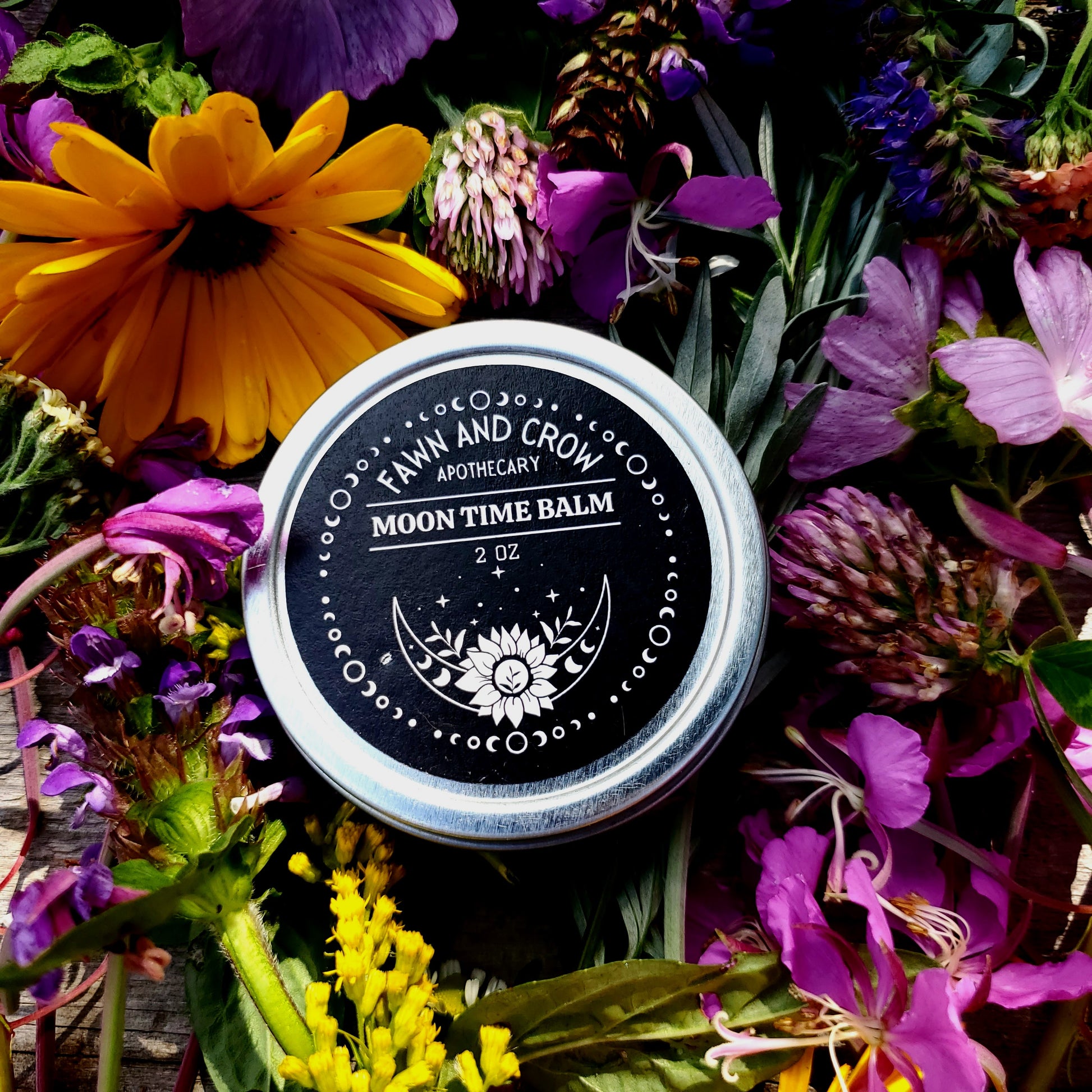 Fawn and Crow Apothecary Moon Time Balm jar surrounded by flowers