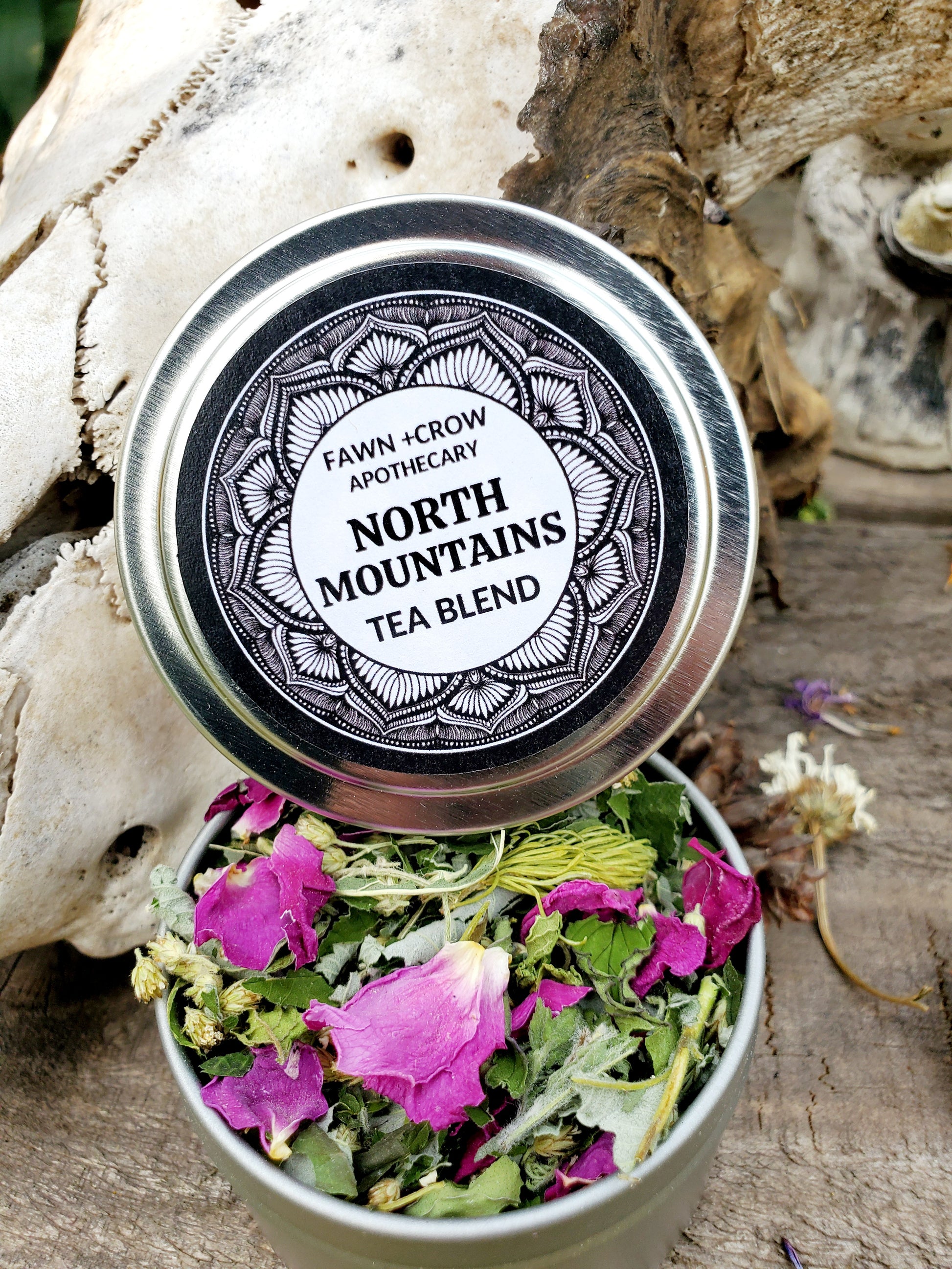 a tin of tea sitting on driftwood