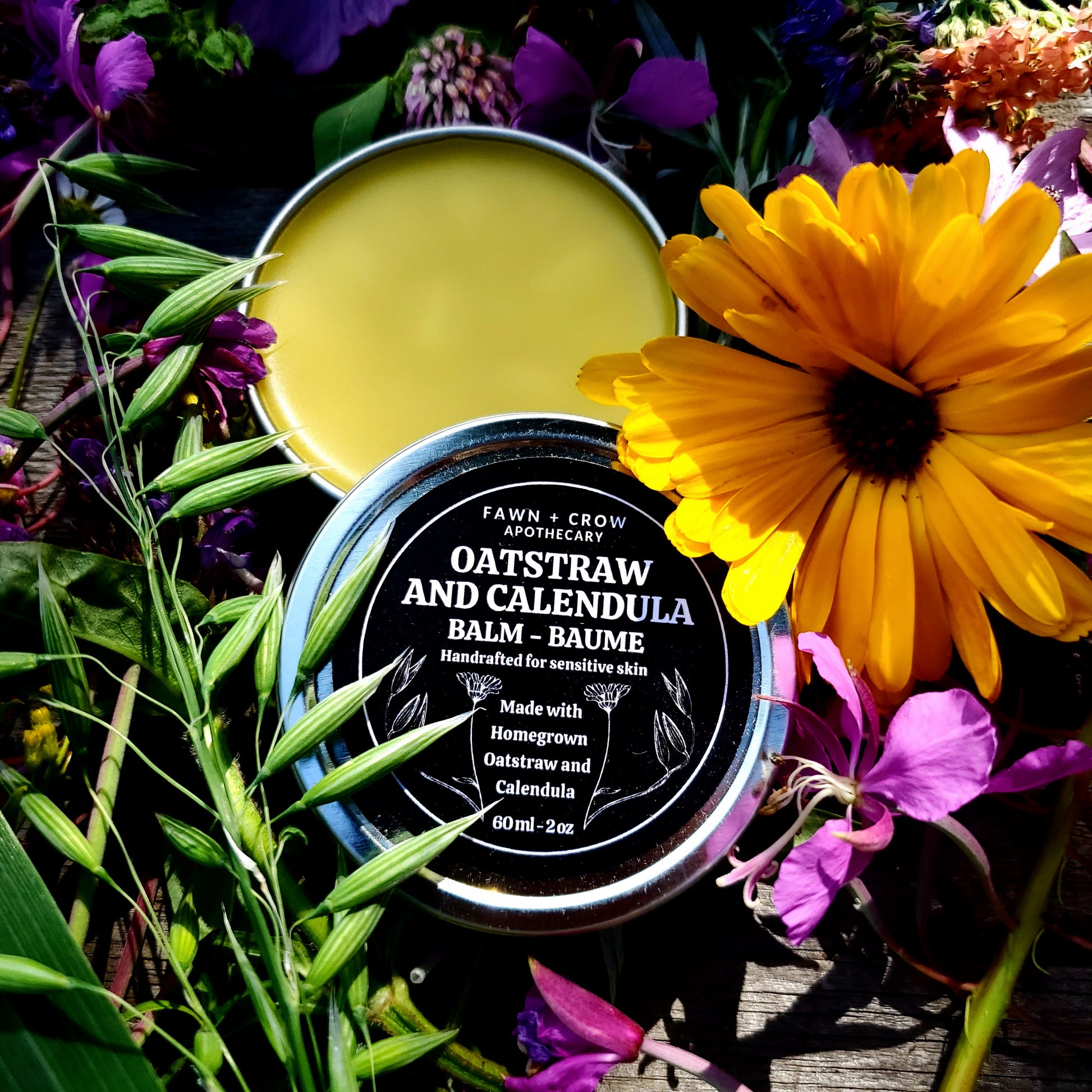 Oatstraw and Calendula balm jar surrounded by flowers and plants