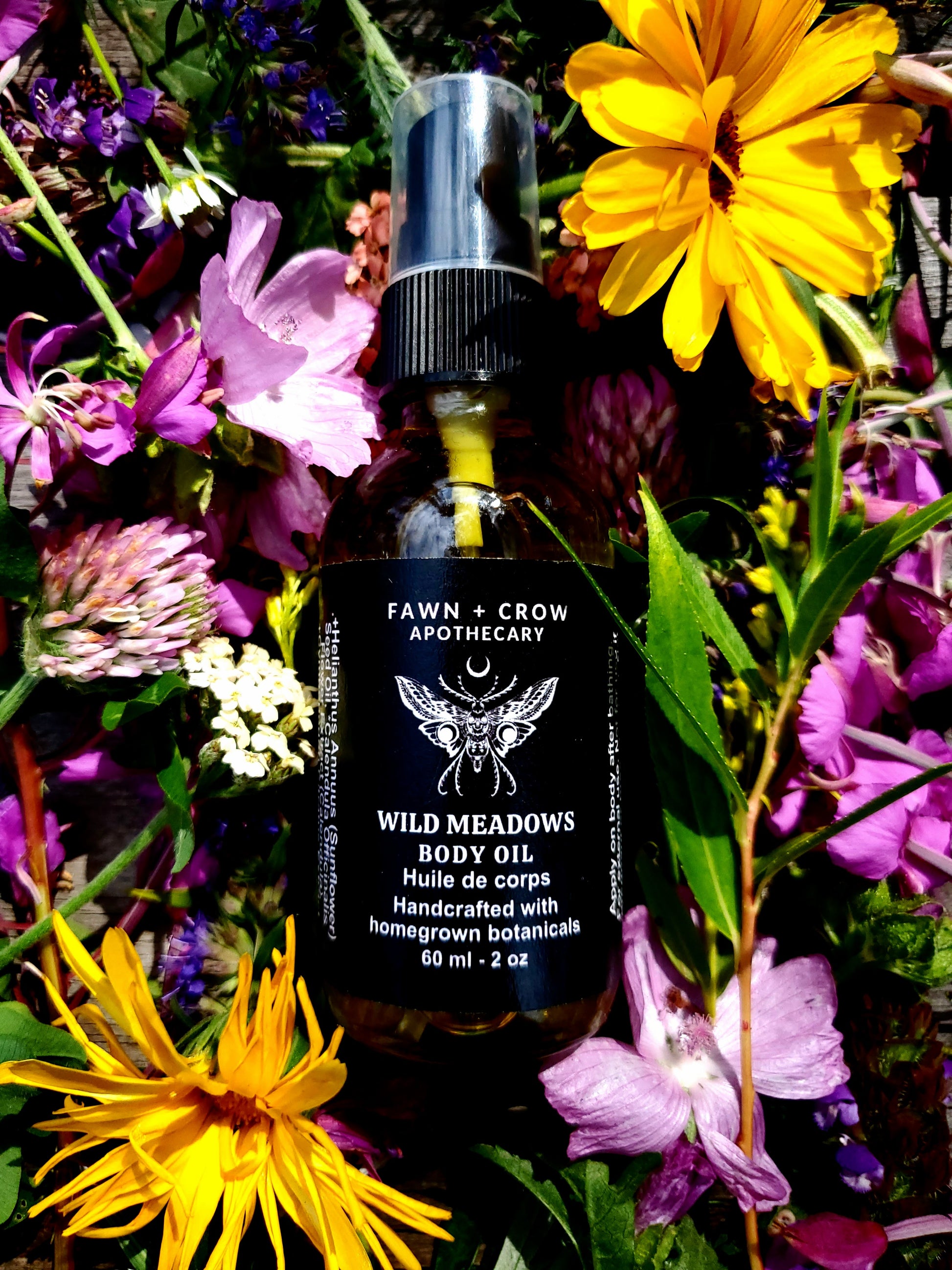 A bottle of medicinal herbal oil surrounded by flowers