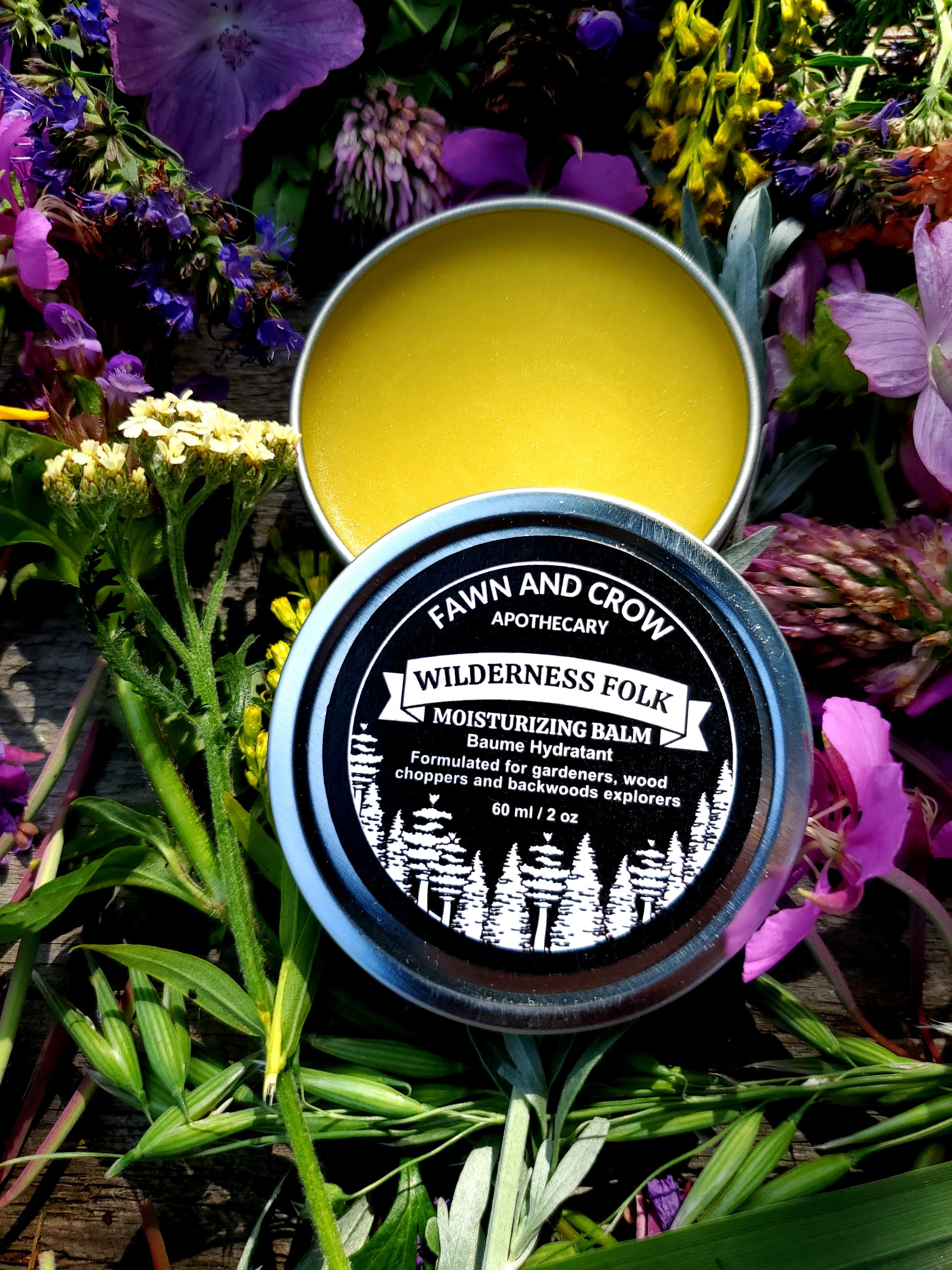 Balm container with lid on a bed of flowers and greenery