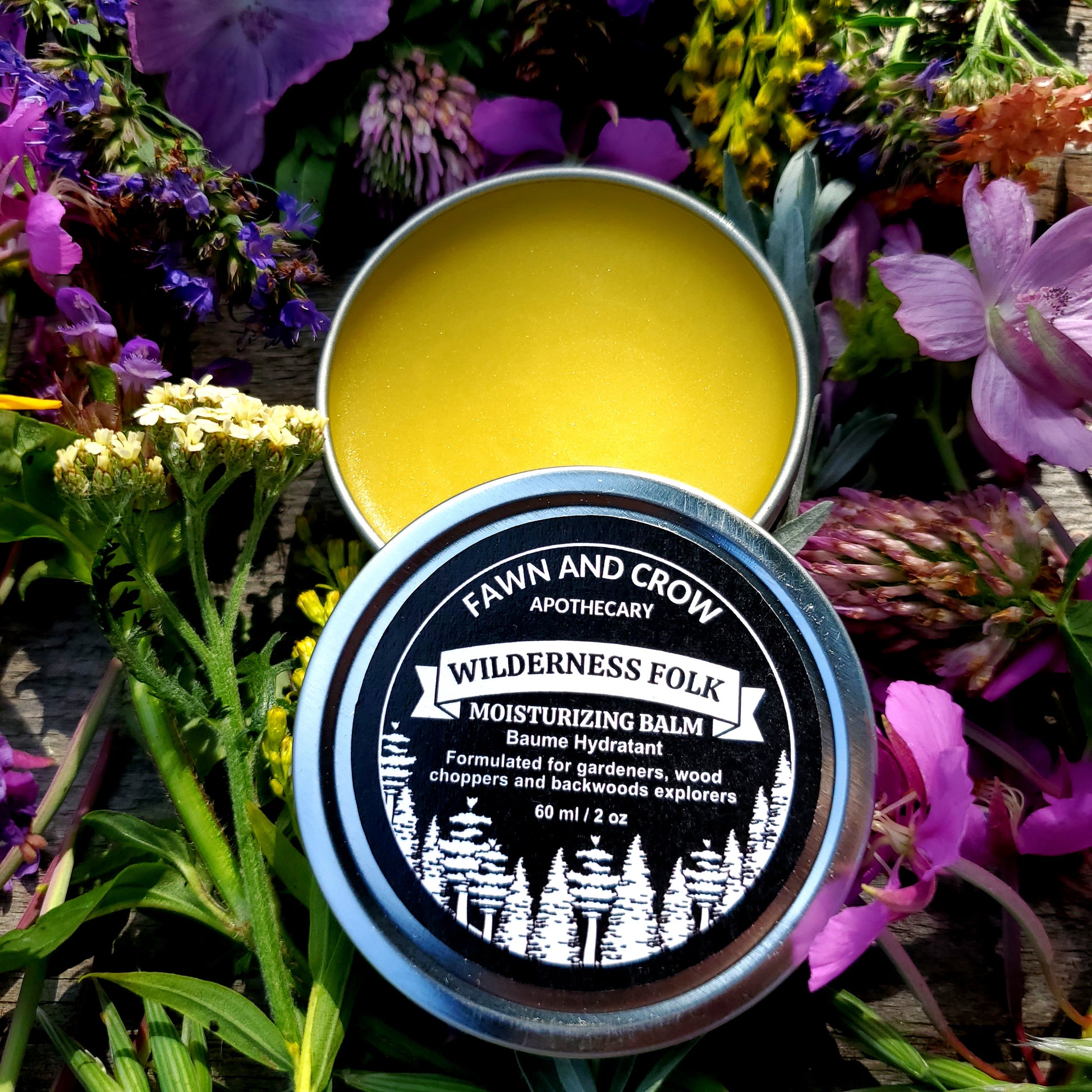 Fawn and Crow balm container with lid on a bed of flowers