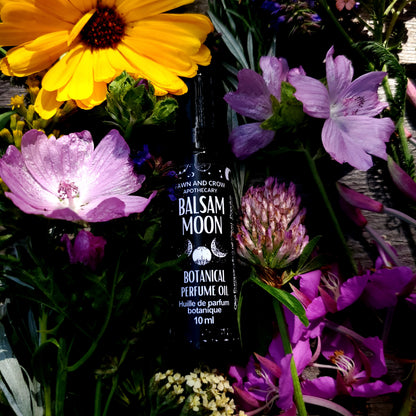 Balsam of the Moon perfume bottle surrounded by flowers