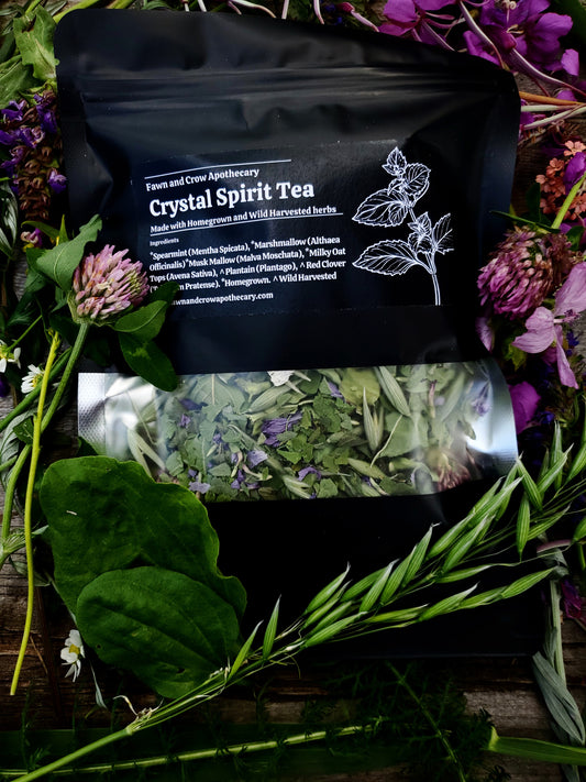 Medicinal tea blend in black pouch surrounded by flowers