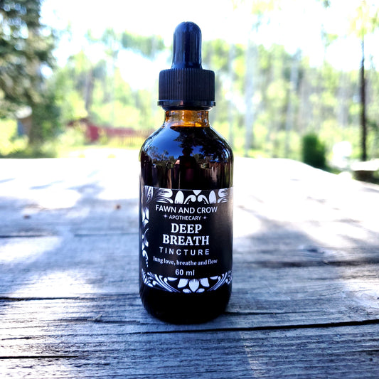 Bottle of 'Deep Breath' tincture on a wooden surface with blurred greenery in the background