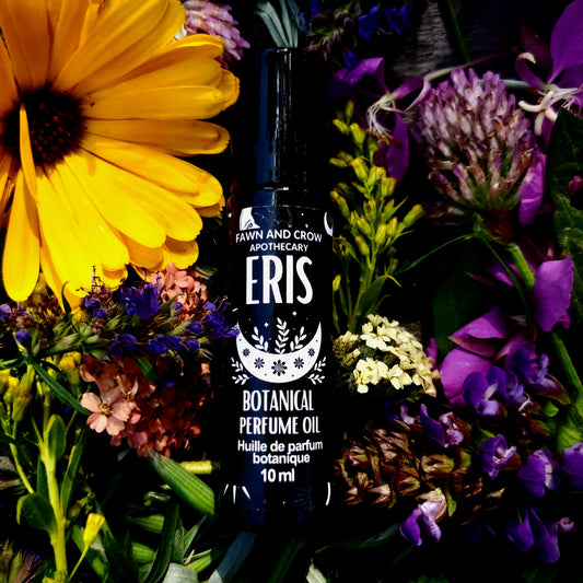 Fawn and Crow Apothecary Eris Botanical Perfume Oil surrounded by flowers