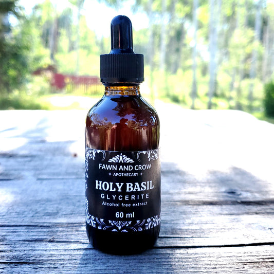 Bottle of Fawn and Crow Apothecary Holy Basil Glycerite on a wooden surface with a blurred natural background