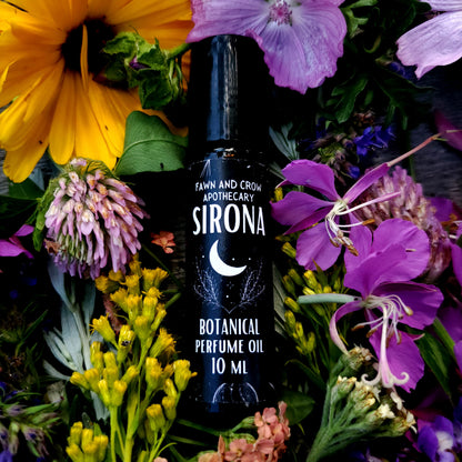 Sirona botanical perfume oil bottle surrounded by colorful flowers