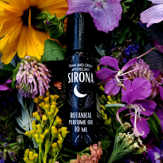 Sirona botanical perfume oil bottle surrounded by colorful flowers