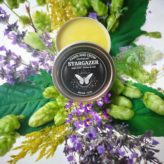 herbal balm with herbs and flowers in background