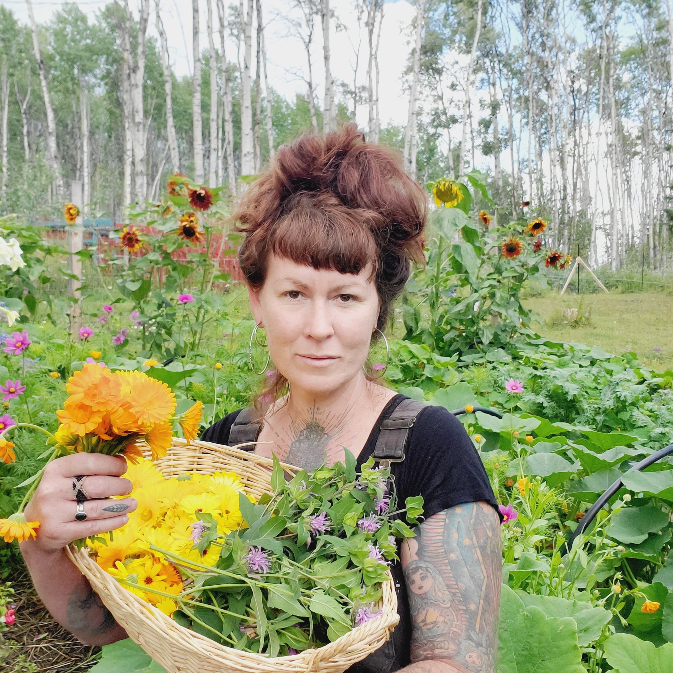 Person holding a basket of flowers in a garden setting